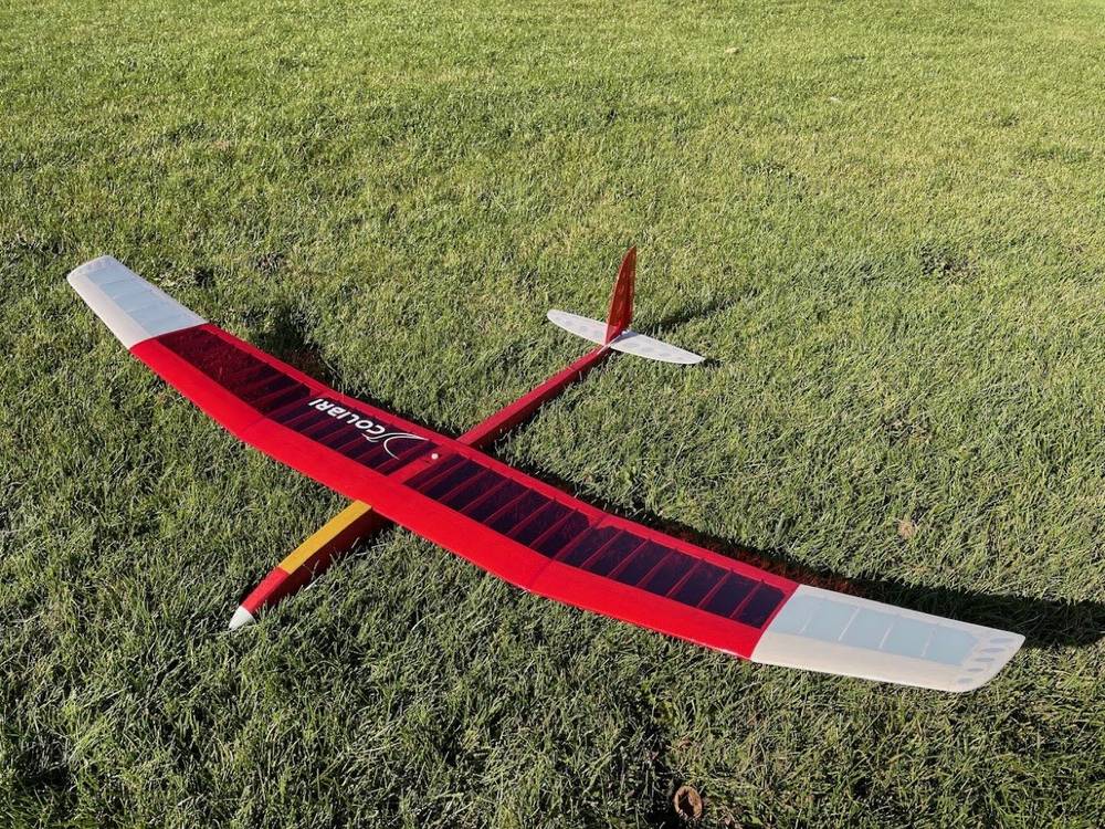 Reference photo from the Colibri 1500 plan set: a red high-aspect-ratio thermal glider resting on grass